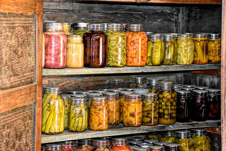 UN ESTANTE DE MADERA LLENO DE MUCHOS FRASCOS DE COMIDA